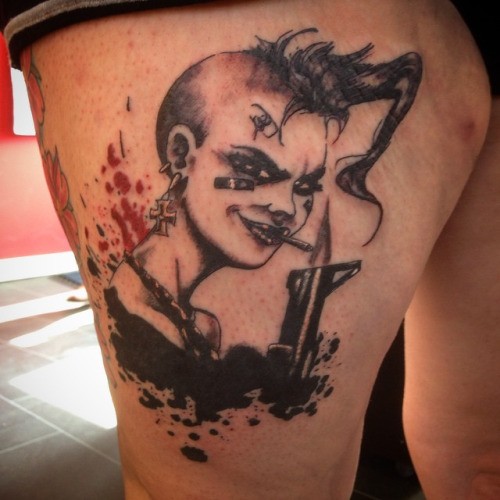 Cartoon style colored thigh tattoo of thug woman with gun