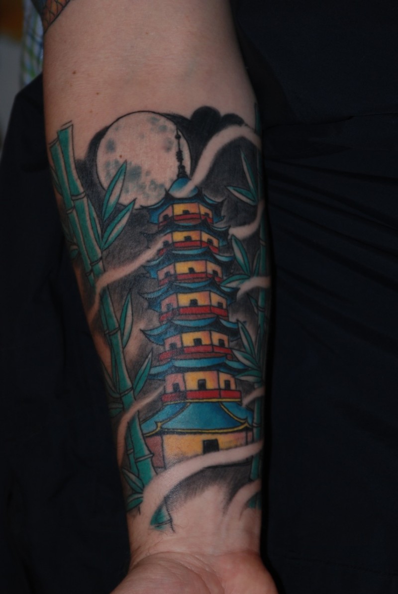 Cartoon style little forearm tattoo of Asian temple and bamboo
