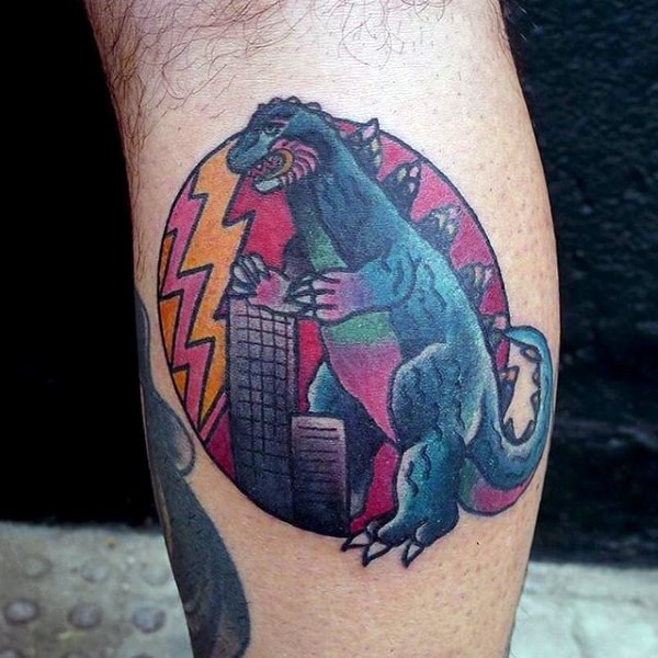 Cartoon style painted and colored Godzilla with city tattoo on leg