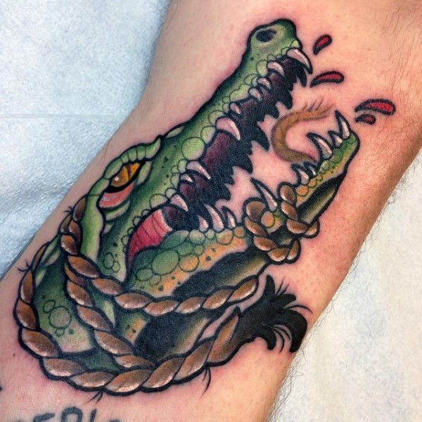 Cartoon style painted colored roped alligator tattoo on arm