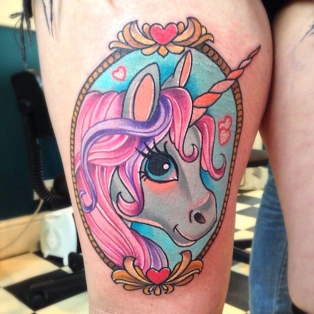 Cartoon style painted colored thigh tattoo of cute unicorn portrait