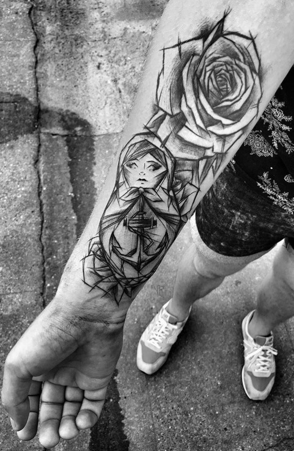 Cartoon themed black ink painted by Inez Janiak forearm tattoo of Matryoshka doll with rose