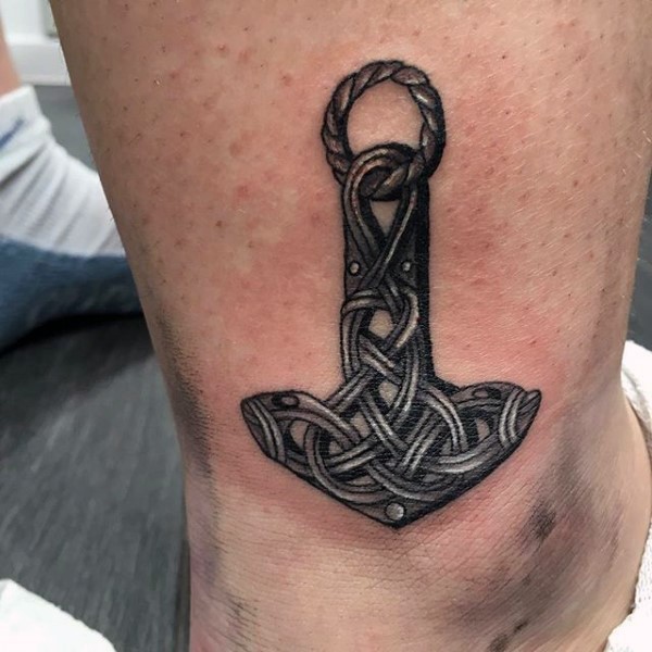 Celtic style black ink leg tattoo of amulet