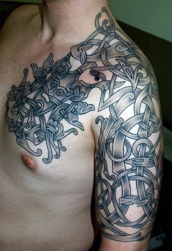 Celtic style black ink shoulder and chest tattoo of various ornaments