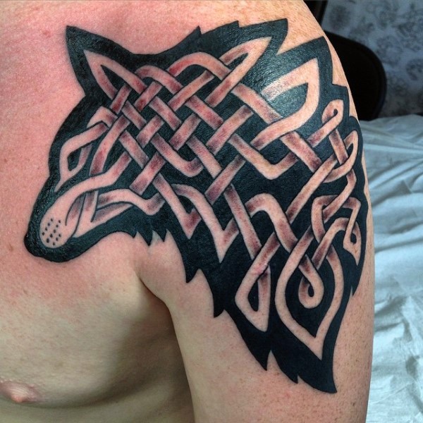 Celtic style colored shoulder tattoo of wolf silhouette