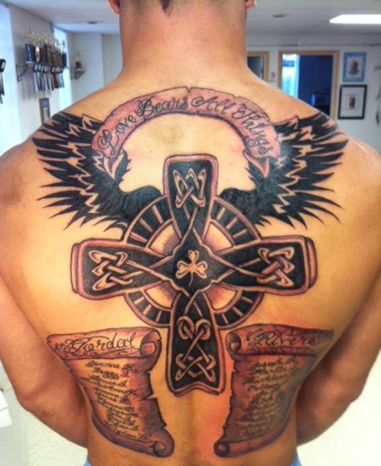 Celtic style winged cross and inscriptions tattoo on back