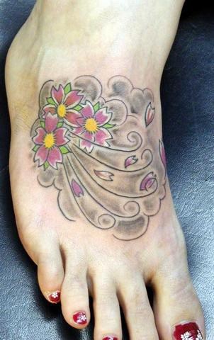 Le tatouage de fleurs de cerise sur le pied