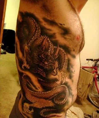 Tatuaje en el costado,
dragón oscuro en nubes