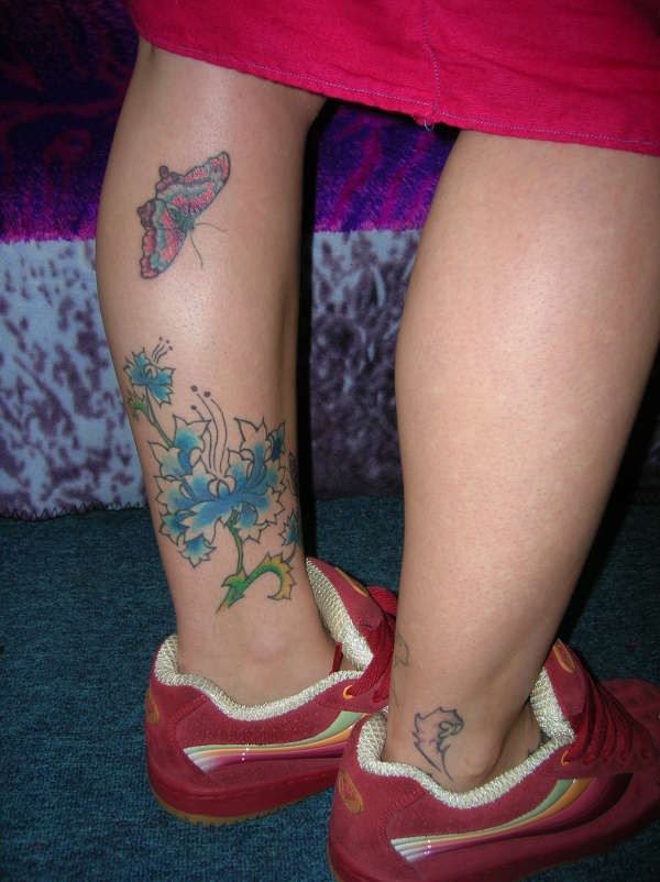 Chinesisches Tattoo mit Blumen und Schmetterling am Bein