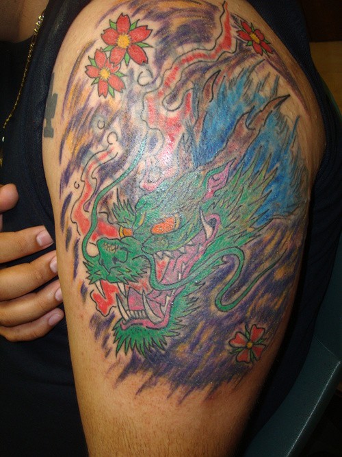 Tatuaje en el brazo,
cabeza de dragón salvaje verde