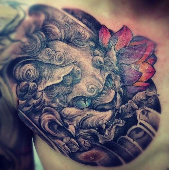 Chinese lion head with red lotus tattoo on shoulder