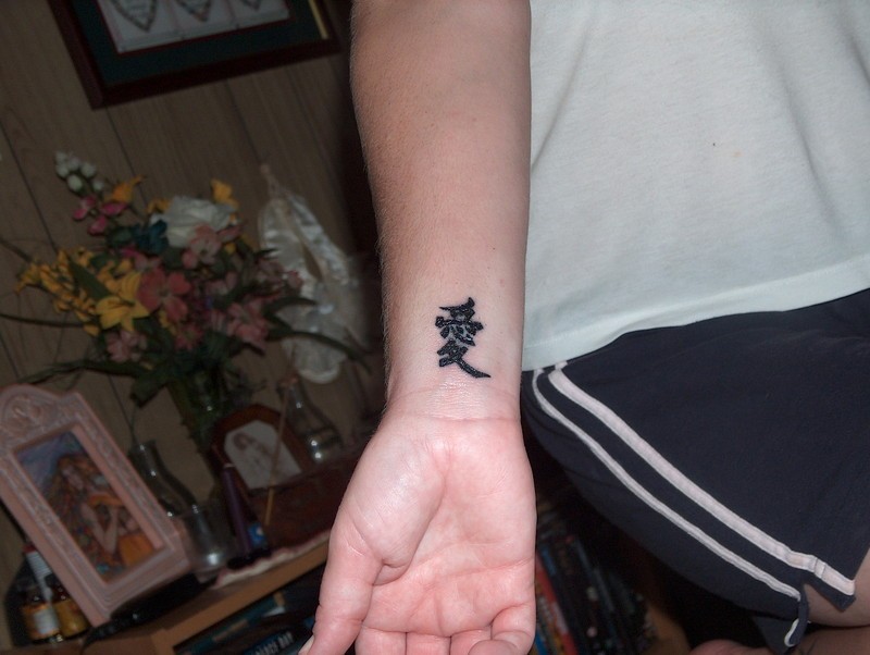 Chinesisches Symbol Tattoo am Handgelenk zum Ausdruck seiner Liebe zu seiner Geliebten