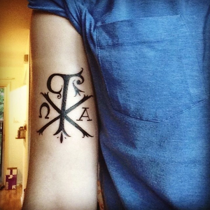 Christus Monogramm Chi Rho spezielles Symbol in dunkler schwarzer Tinte Tattoo am Bizeps
