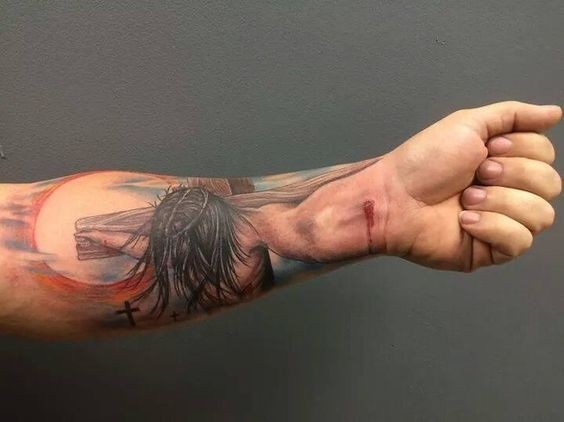 Farbiger Jesus auf Kreuz christliches Tattoo am Handgelenk