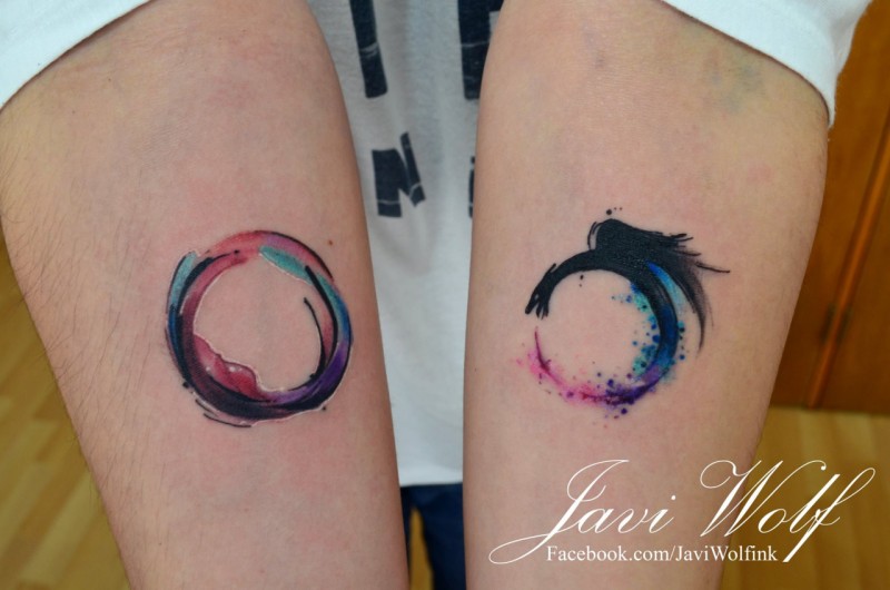 Circle and unfinished circle forearm tattoo by Javi Wolf with colored watercolor details