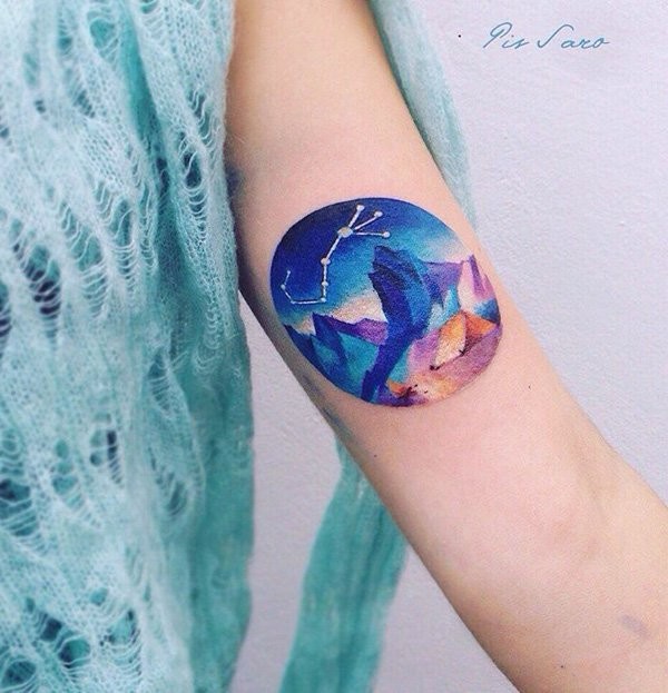 Circle shaped arm tattoo of night sky mountain with zodiac symbol
