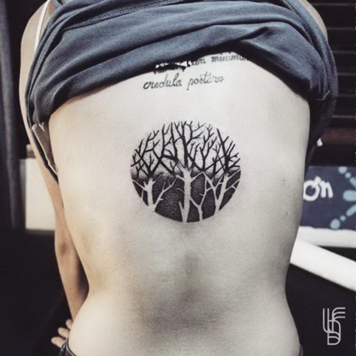 Circle shaped black ink back tattoo of forest
