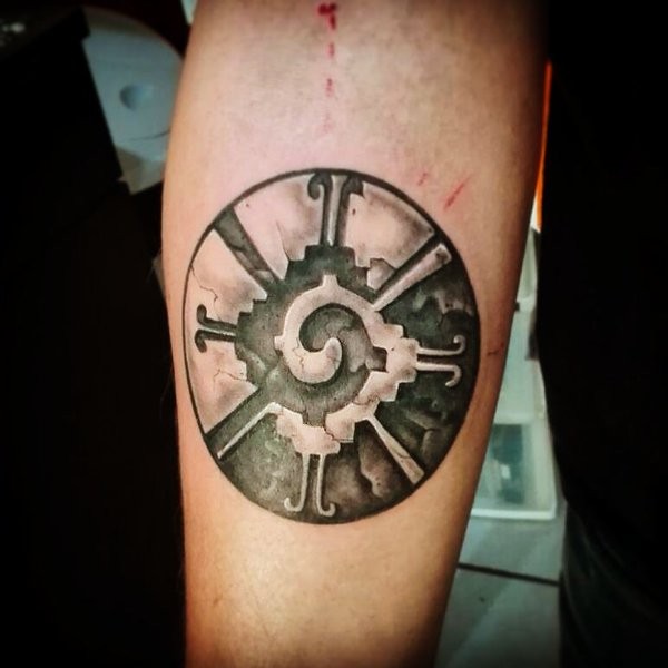 Circle shaped black ink forearm tattoo of ancient tablet