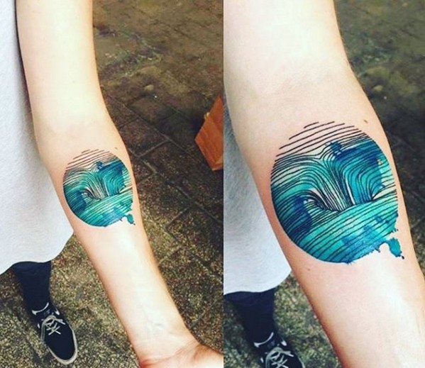 Circle shaped colored by Joanna Swirska forearm tattoo of waterfall