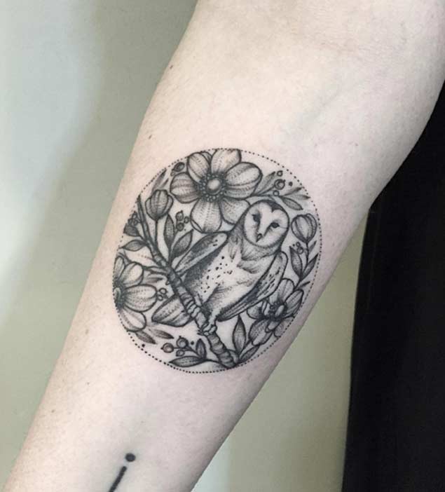 Tatuaje en el antebrazo,
lechuza hermosa en la rama y flores diferentes, dibujo monocromo