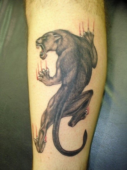 Tatuaje en la pierna de una pantera subiendo.
