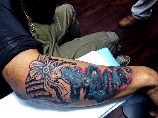 Colored arm tattoo of ancient Egypt statue with night sky