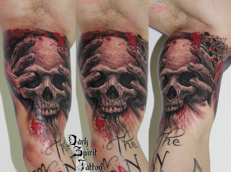 Colored biceps tattoo of bloody skull with human hands