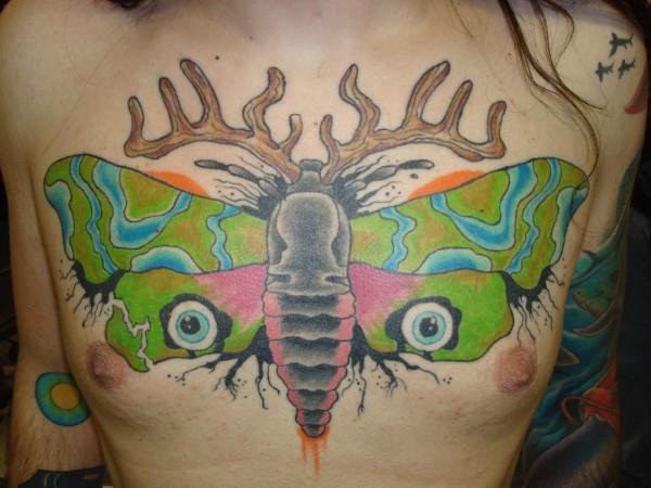 Colored chest tattoo of interesting butterfly with horns and eyes