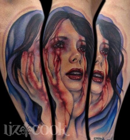 Colored creepy looking arm tattoo of bloody woman face