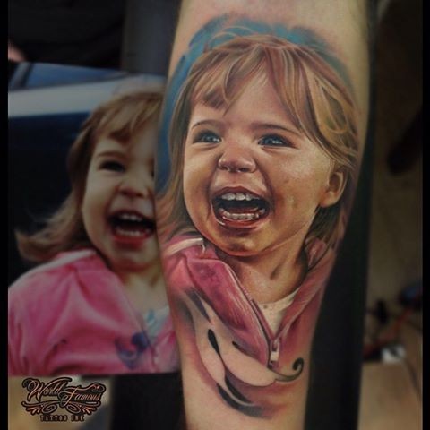 Colored forearm tattoo of smiling girl portrait