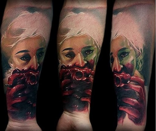 Colored horror style creepy looking forearm tattoo of bloody woman with heart