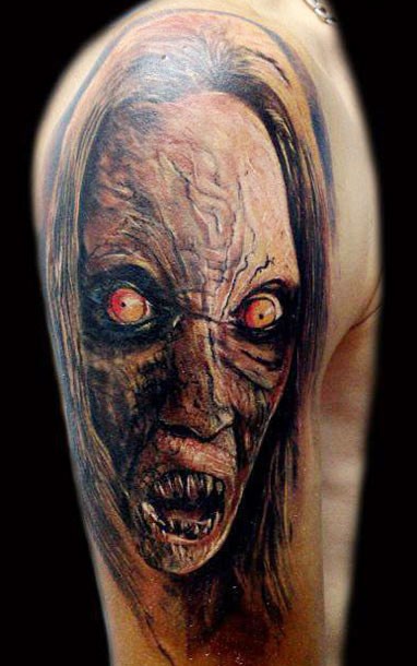 Colored horror style creepy looking shoulder tattoo of monster face