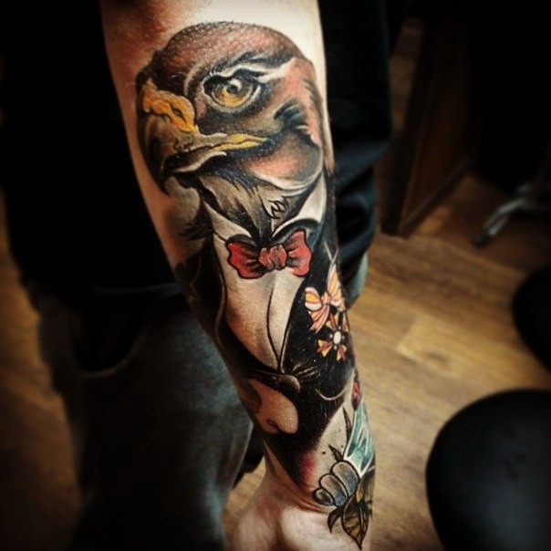 Colored illustrative style arm tattoo of eagle with tox and flowers
