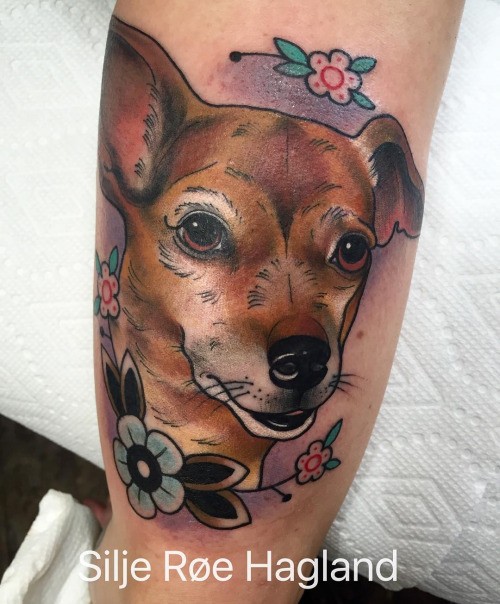 Colored illustrative style arm tattoo of cute dog with flowers