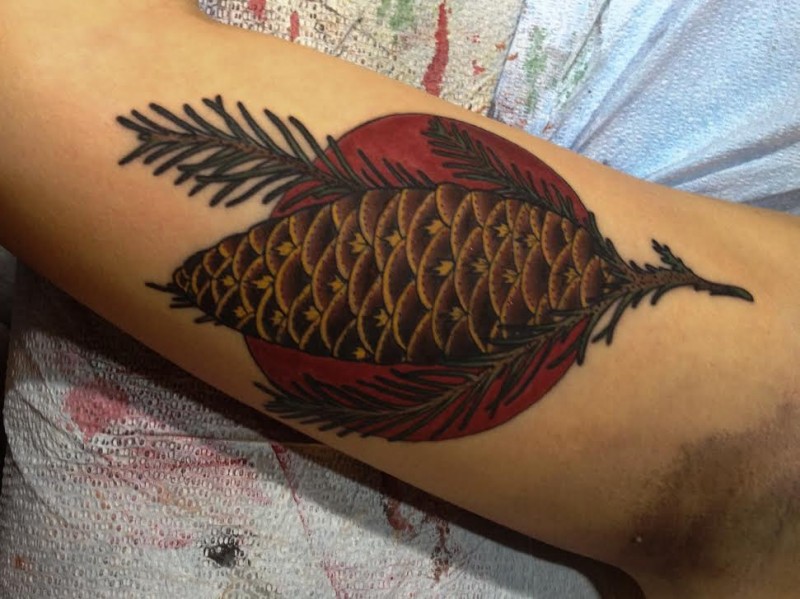 Colored illustrative style arm tattoo of cone stylized with red circle