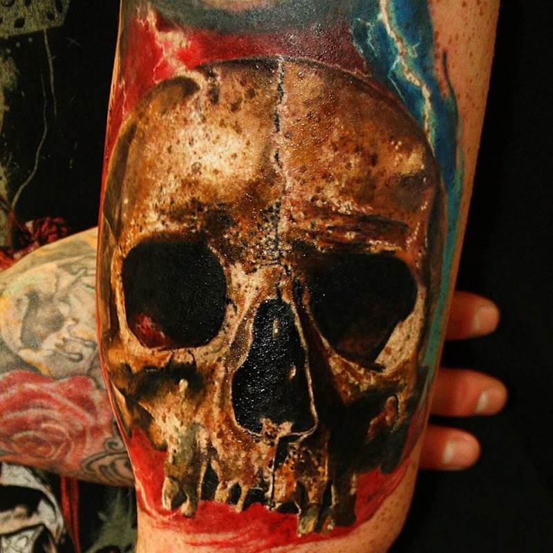 Colored illustrative style arm tattoo of very detailed human skull