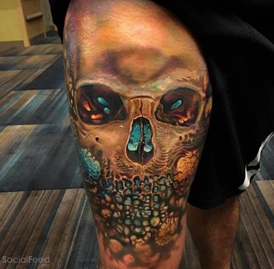 Colored illustrative style thigh tattoo of skull