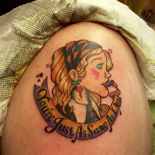 Colored illustrative style woman portrait tattoo on shoulder with lettering