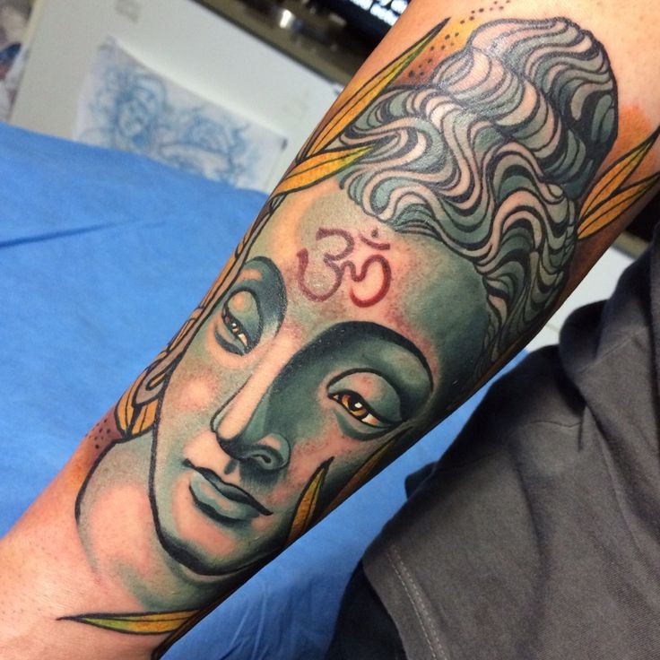 Colored impressive looking arm tattoo of Buddha statue with ornament