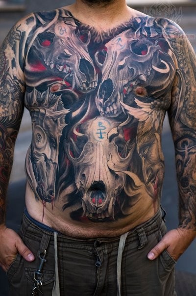 Colored large interesting looking chest and belly tattoo of demonic animal skulls