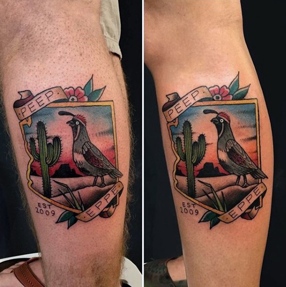 Colored leg tattoo of picture with desert cactus, bird and lettering