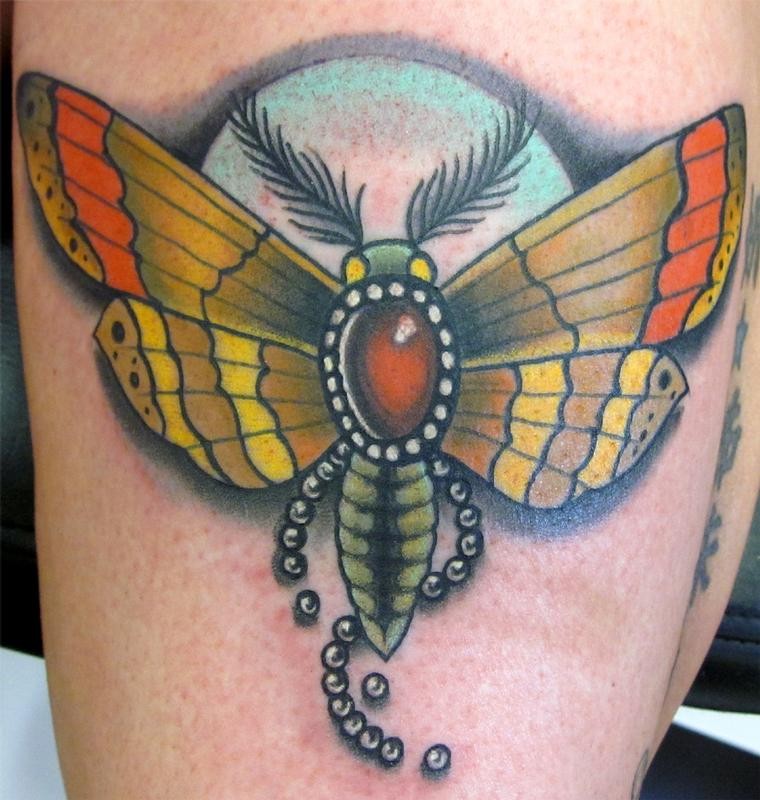 Colored moth tattoo on leg