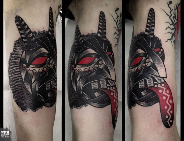 Colored mystical looking biceps tattoo of demonic face