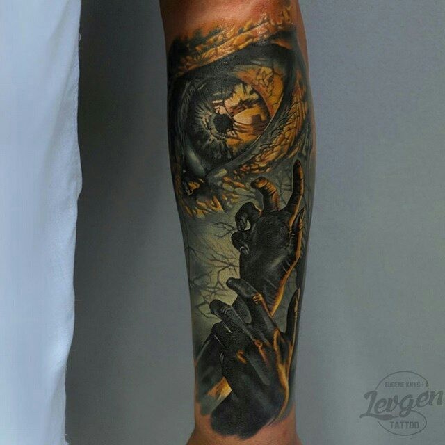 Colored mystical looking forearm tattoo of creepy hands and eye
