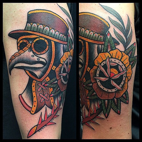 Colored old school style arm tattoo of plague doctors mask with rose