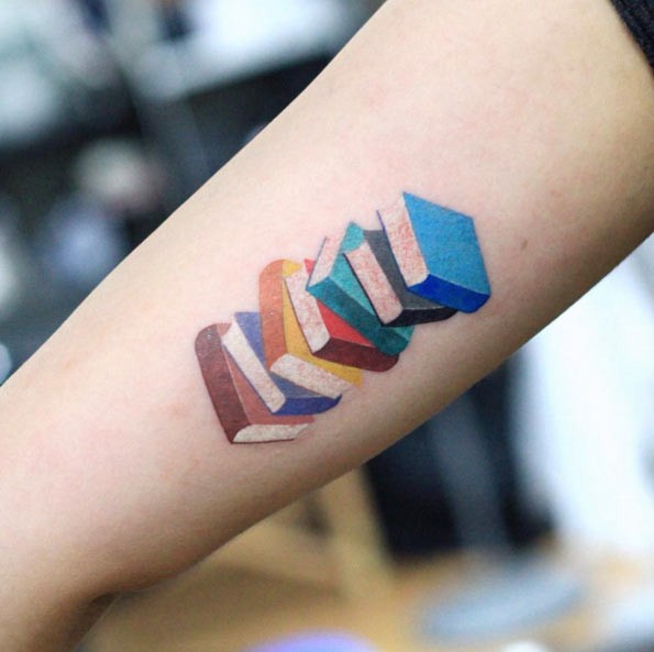 Colored pale of books forearm tattoo