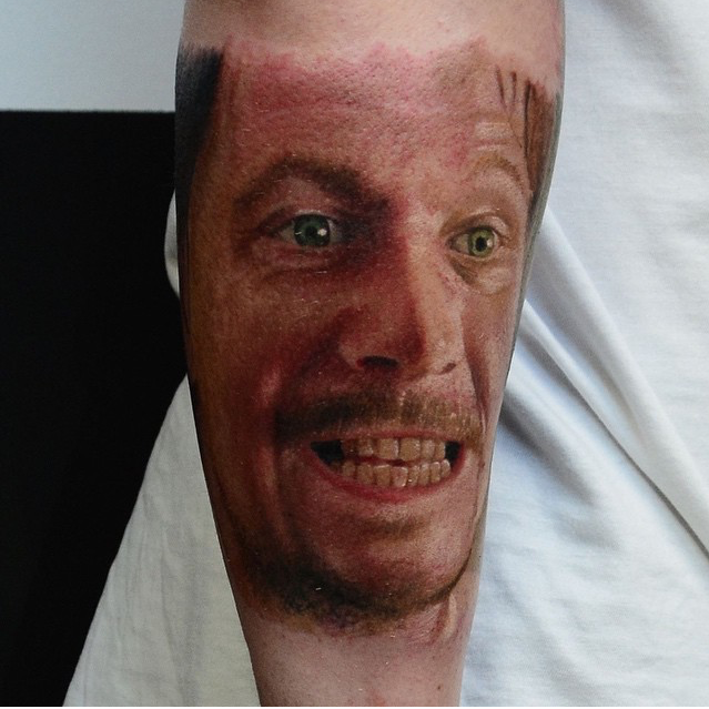 Colored portrait style arm tattoo of man portrait