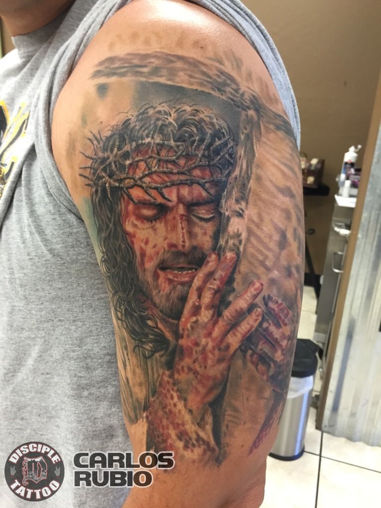 Colored shoulder tattoo of dramatic Jesus with cross