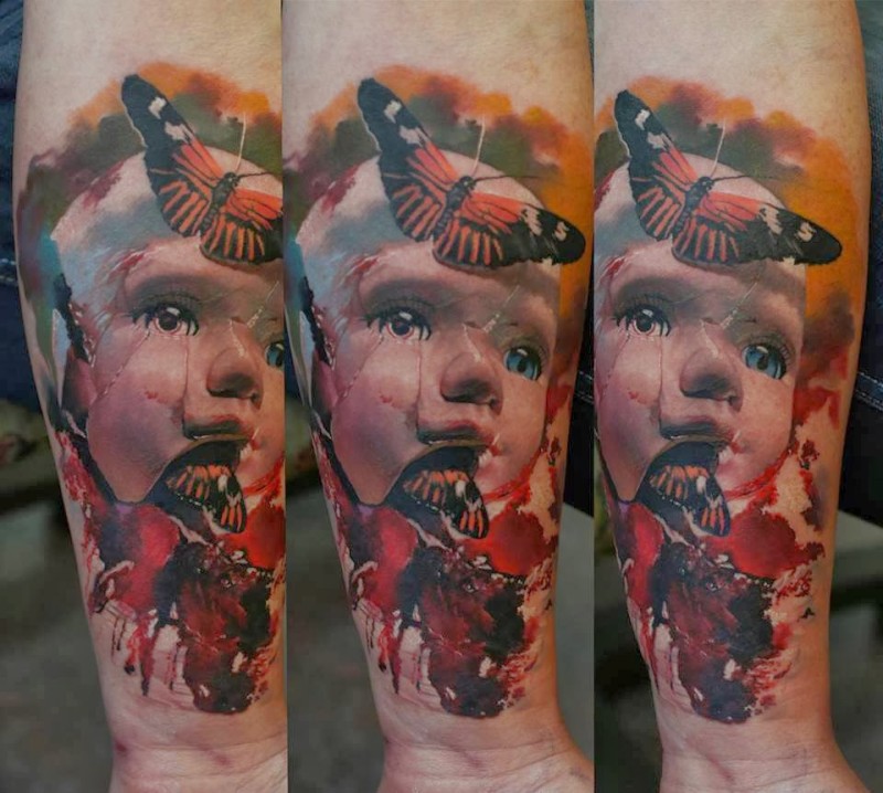 Colored surrealism style colored forearm tattoo of doll with butterflies