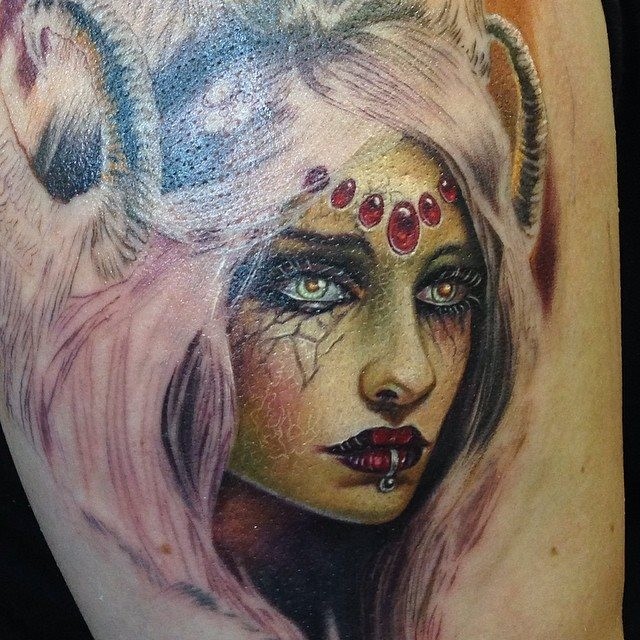 Colored thigh tattoo of demonic woman with pierced leap